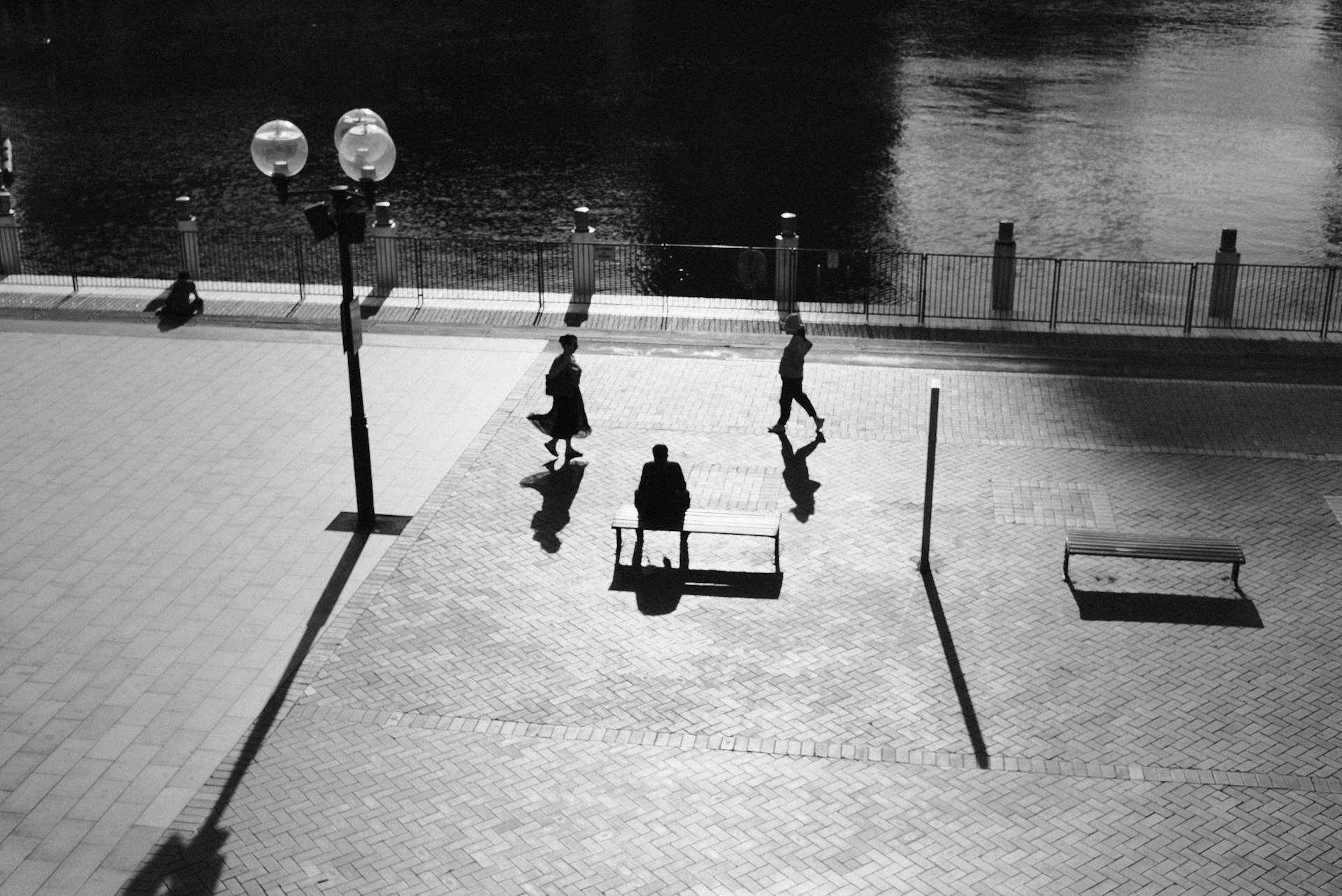 A black and white photo of people sitting on benches